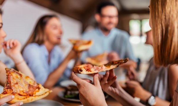 Eating pizza with friends. Close-up.